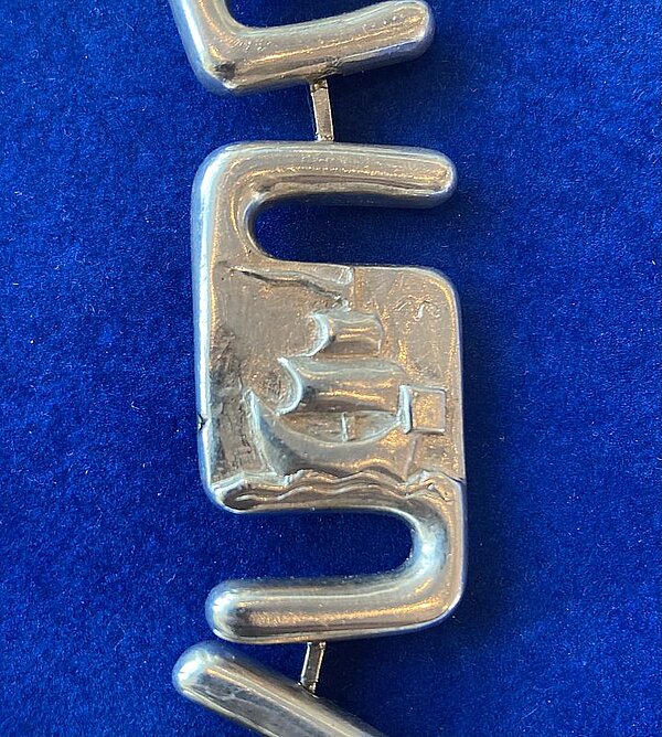 kleurenfoto met een detail van de ambtsketen: een koggeschip