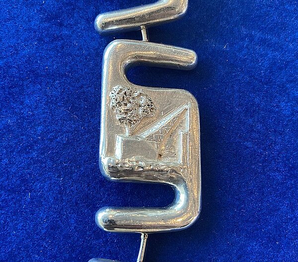 kleurenfoto met een detail van de ambtsketen: bouwactiviteiten