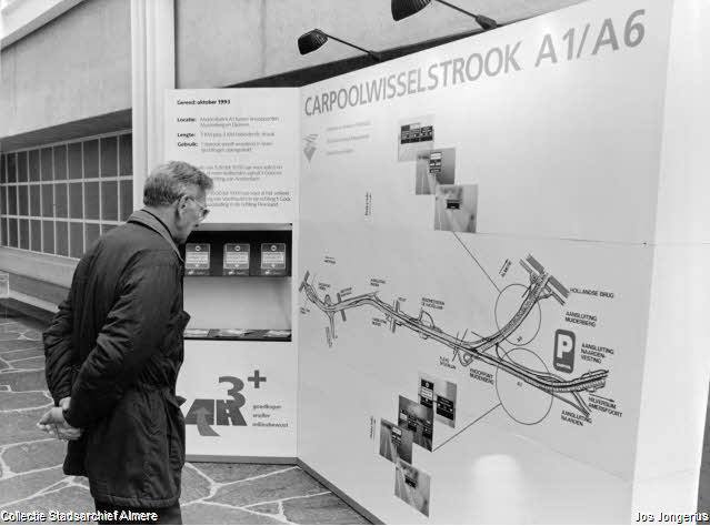 Bezoeker stadhuis bekijkt infopaneel over de carpoolwisselstrook in 1993 (Jos Jongerius, collectie Stadsarchief Almere)